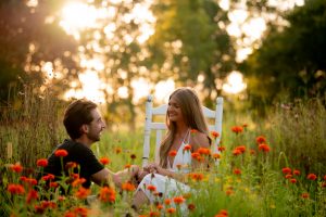 Engagement portrait session fiancé sitting in a chair while soon to be husband proposes